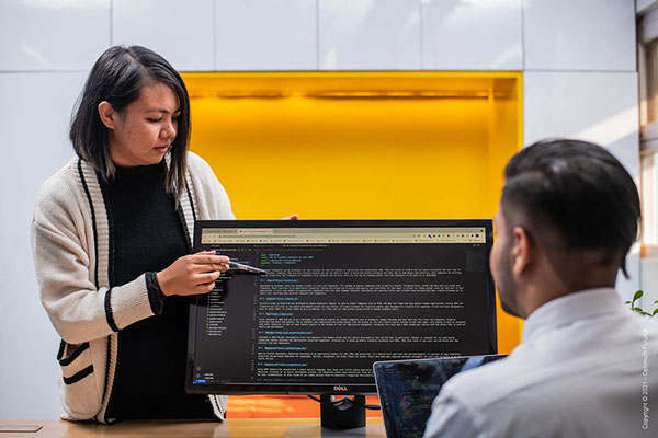 women employee coding on laptop